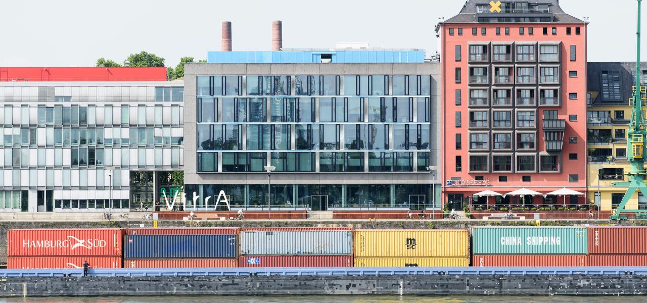 Panoramablick vom Rhein auf das ECR-Office mit Vitra Logo und Containerschiff