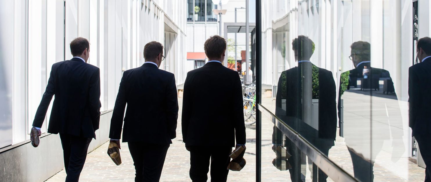 Headerbild für die Rubrik Business, Geschäftsleute spazieren in der Pause durch den Rheinauhafen