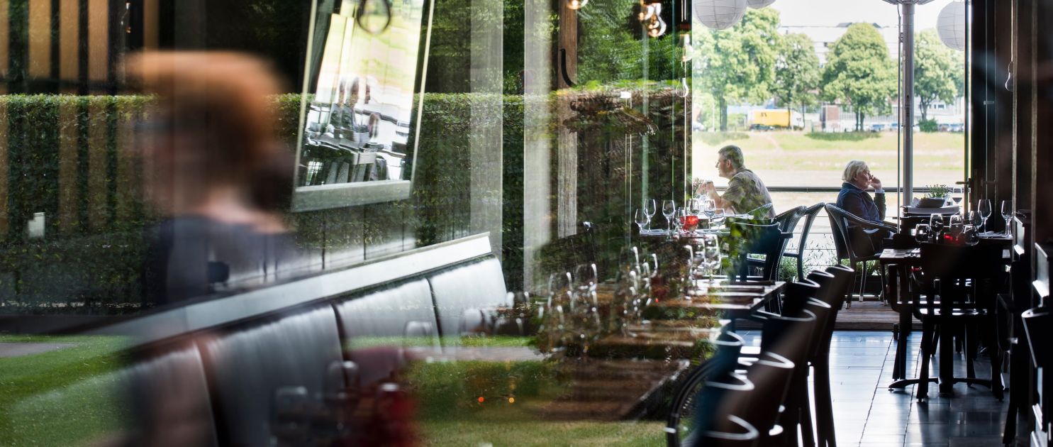 Headerbild für die Gastronomie-Rubrik, Blick in ein Restaurant im Rheinauhafen, dynamische Spiegelung und Unschärfe,