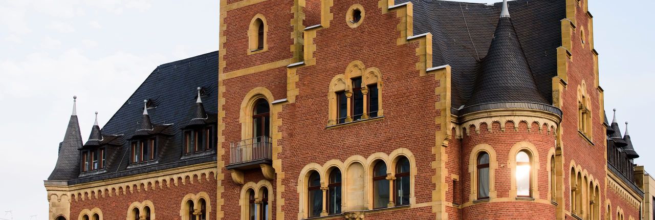 Das Hafenamt hat eine zweifarbig gestaltete Backsteinfassade und die Rundbögen der Fenster erinnern an die Romanik