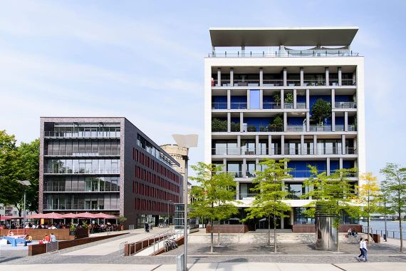 Spannende Architekturfotografie des Luthergebäudes mit Außengastronomie und dem Gebäude rhein3